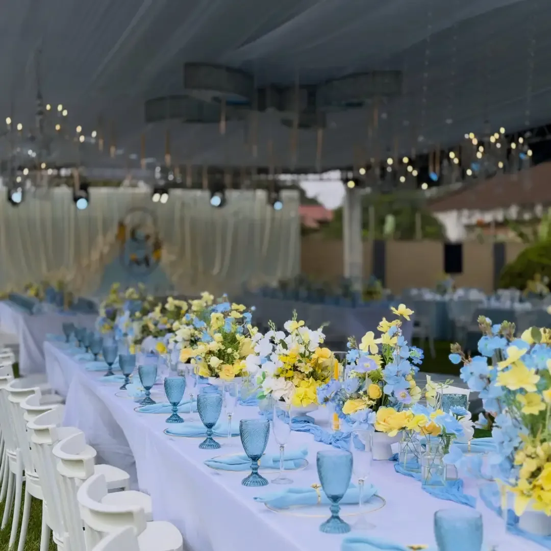 Sky blue and lemon long banquet table with mixed florals by Smartest Decor