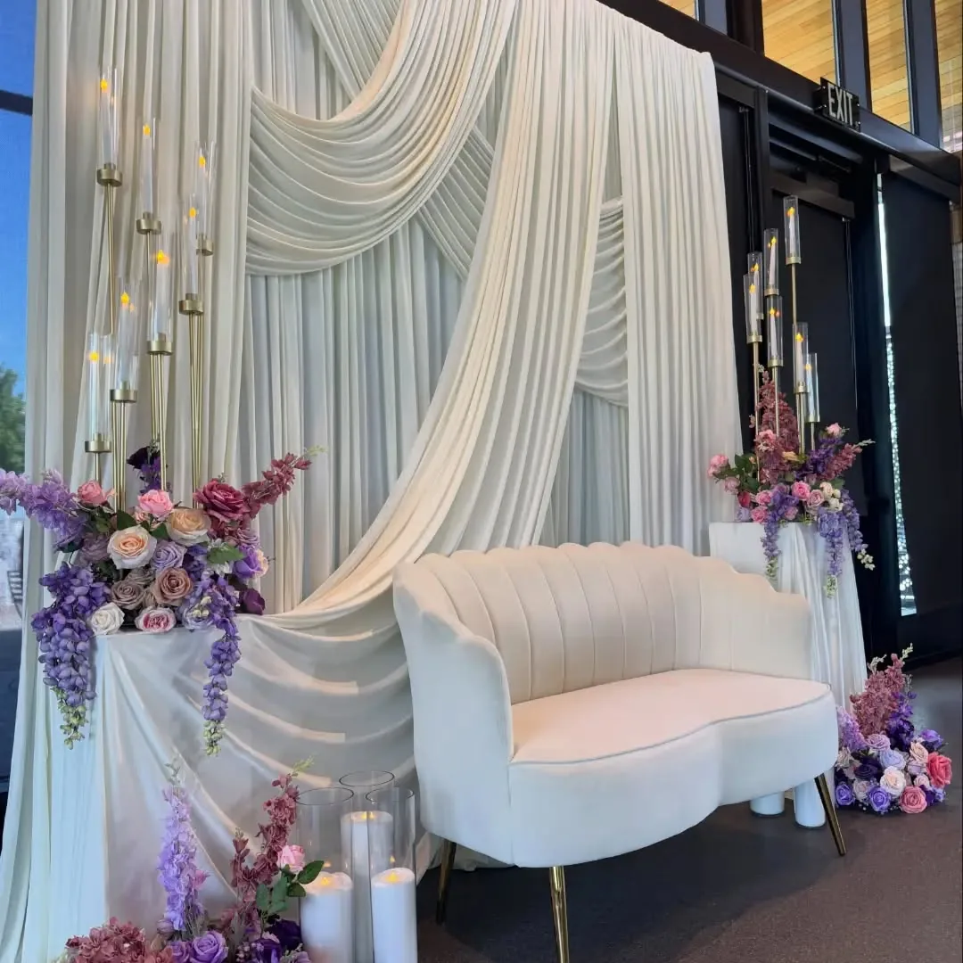 White draped backdrop with blush loveseat