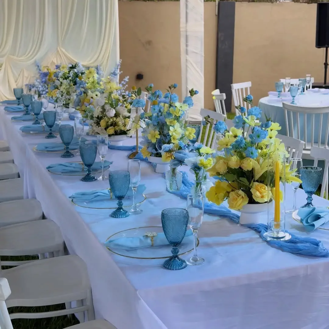 Sky blue and lemon long banquet table with mixed florals by Smartest Decor