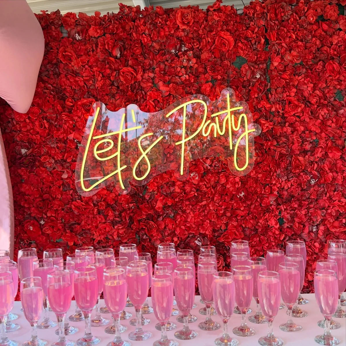 Deep red rose wall with a neon sign by Smartest Decor