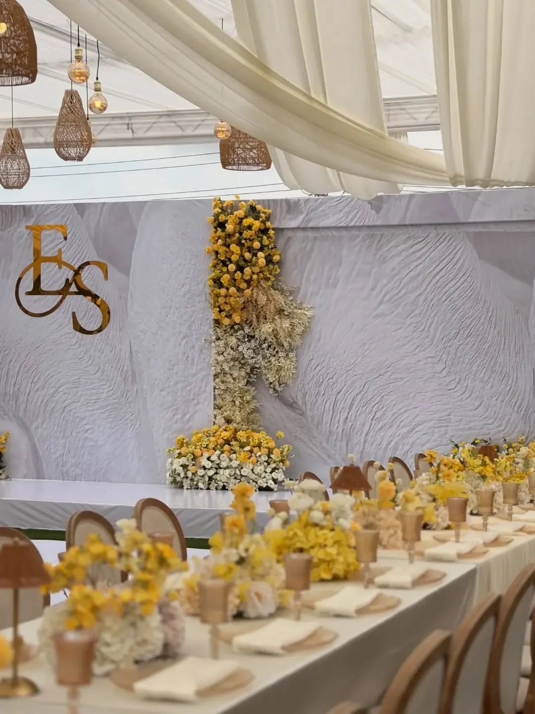 Yellow and cream event with gold monogram backdrop by Smartest Decor