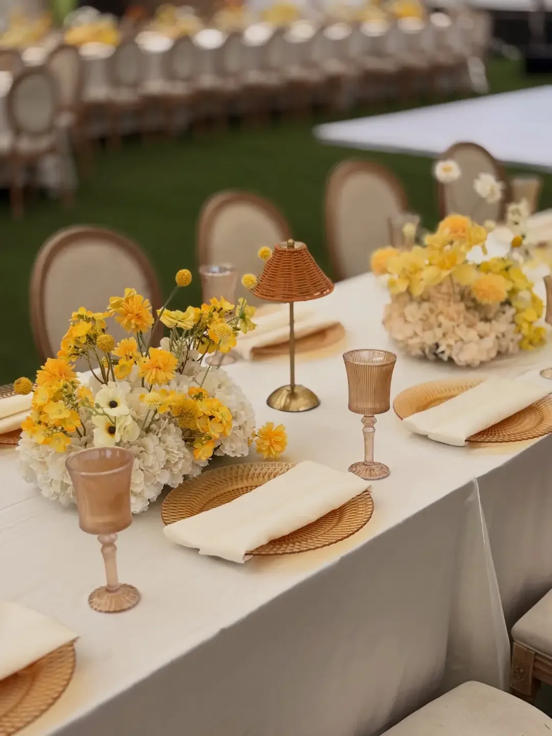 Yellow and cream place setting with rattan charger and amber glassware by Smartest Decor